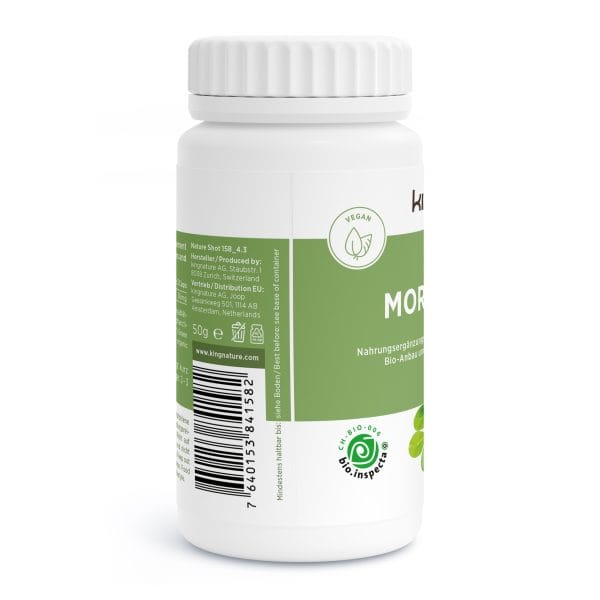 Eine weiße Plastikflasche mit grünem Etikett, auf dem vegane Moringa-Kapseln abgebildet sind. Das Etikett zeigt ein Blattsymbol, einen Barcode, deutschen Text, Zertifizierungslogos und einen gerippten weißen Deckel.